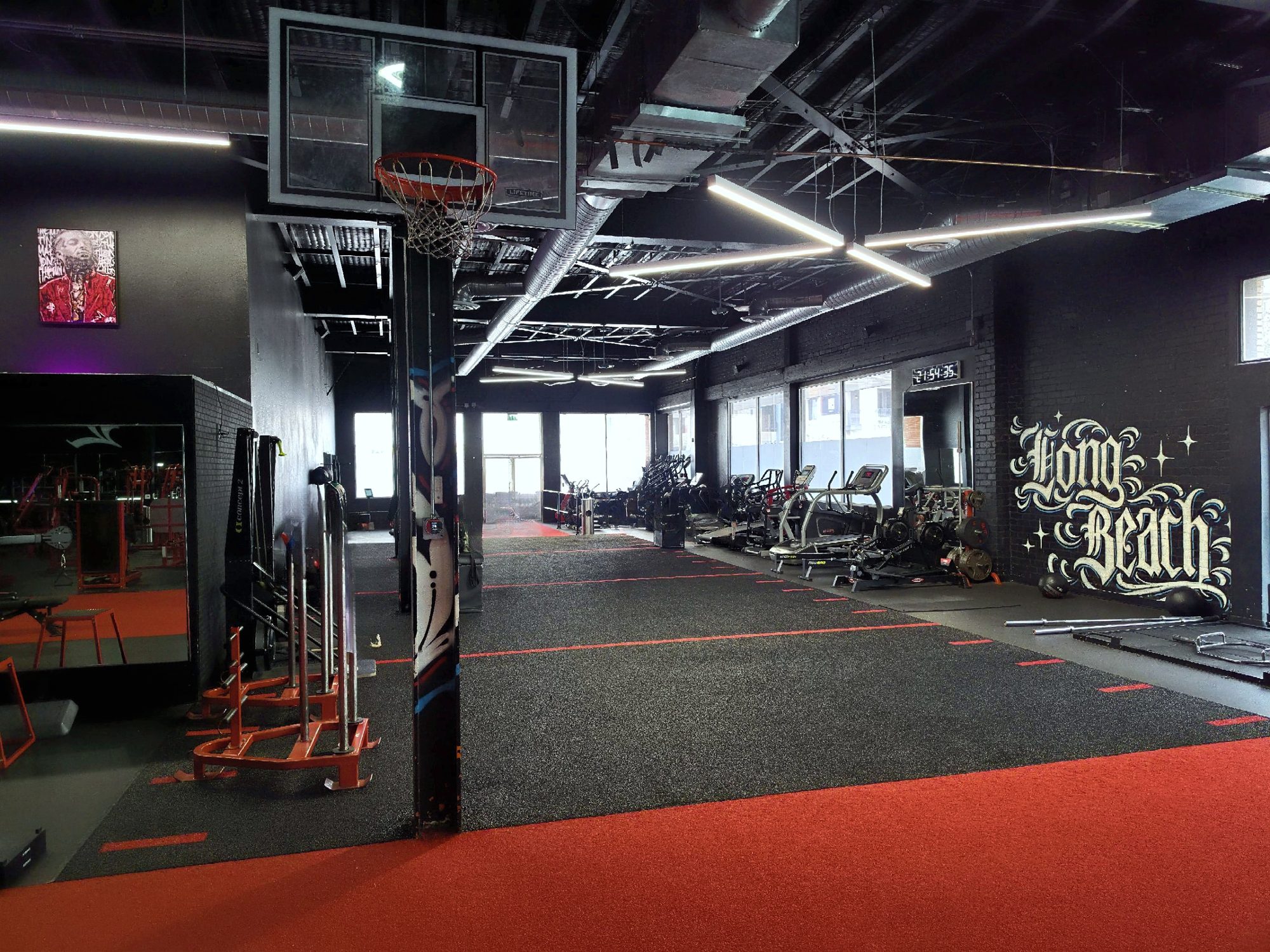 The Long Beach floor: turf lanes, cardio row along the windows, and a Long Beach mural on the back wall