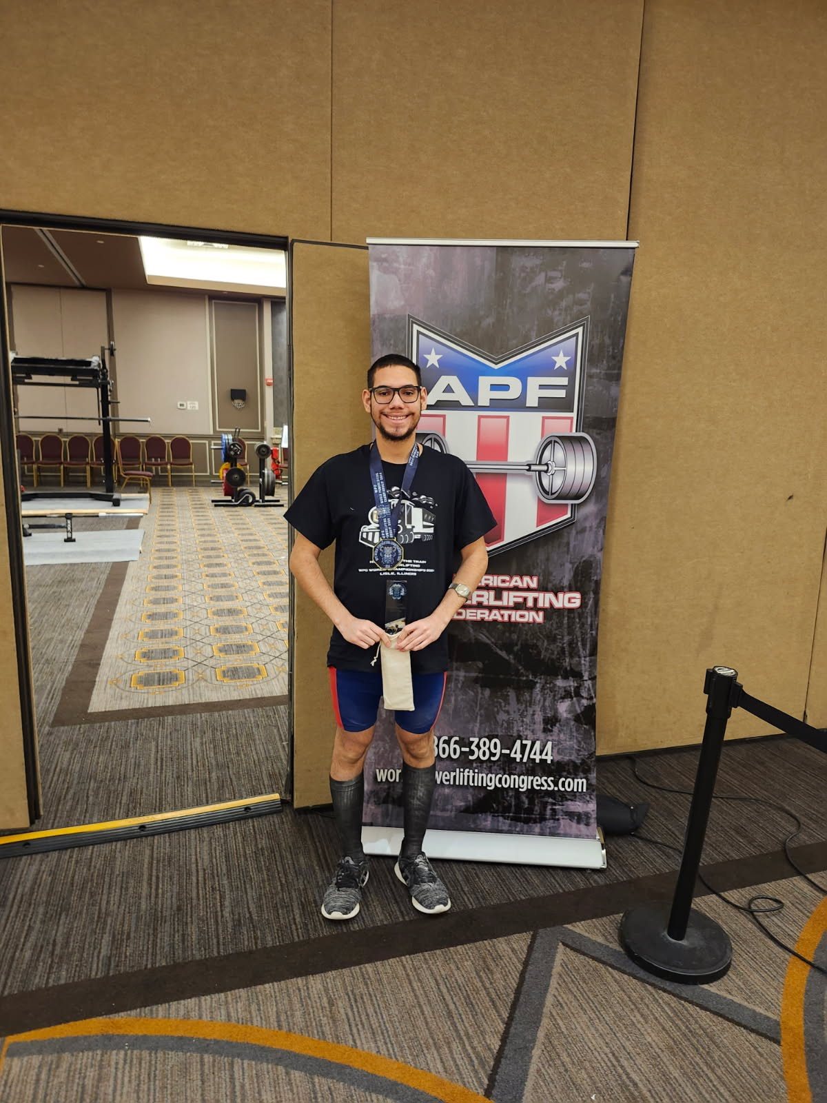 Daniel Courville with his medal in front of the APF banner