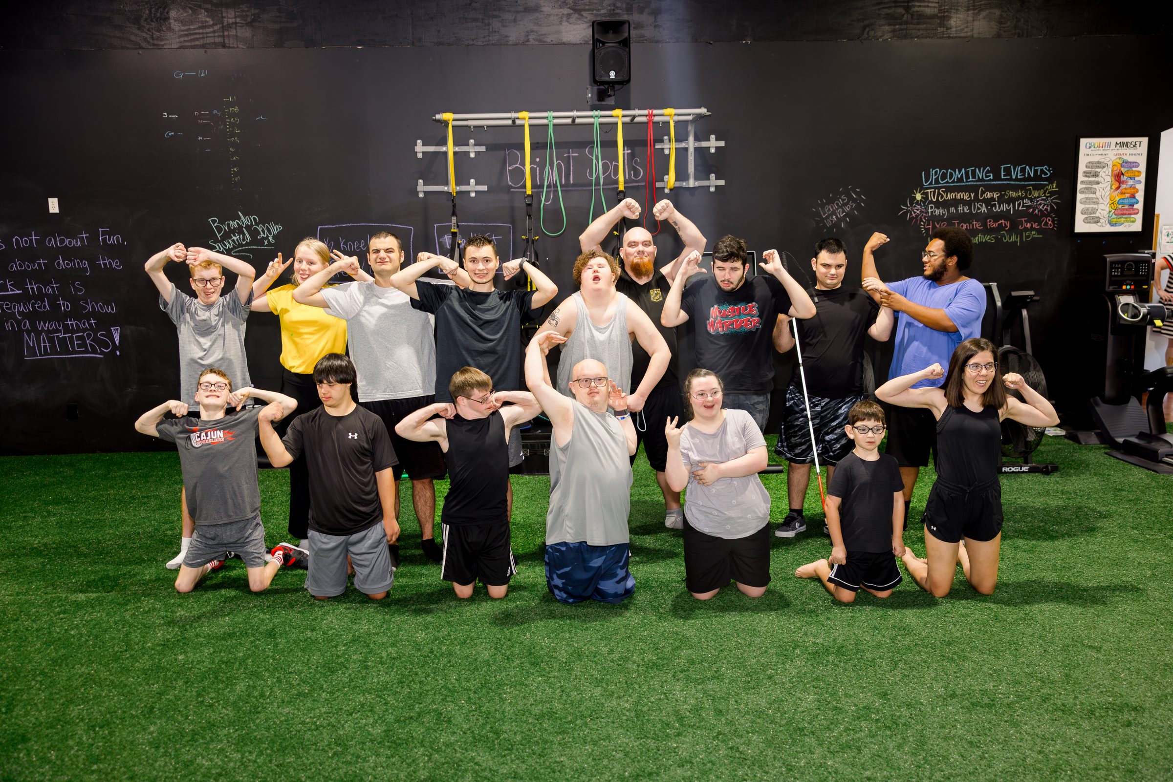 A big group of athletes and coaches on the turf, flexing for the camera