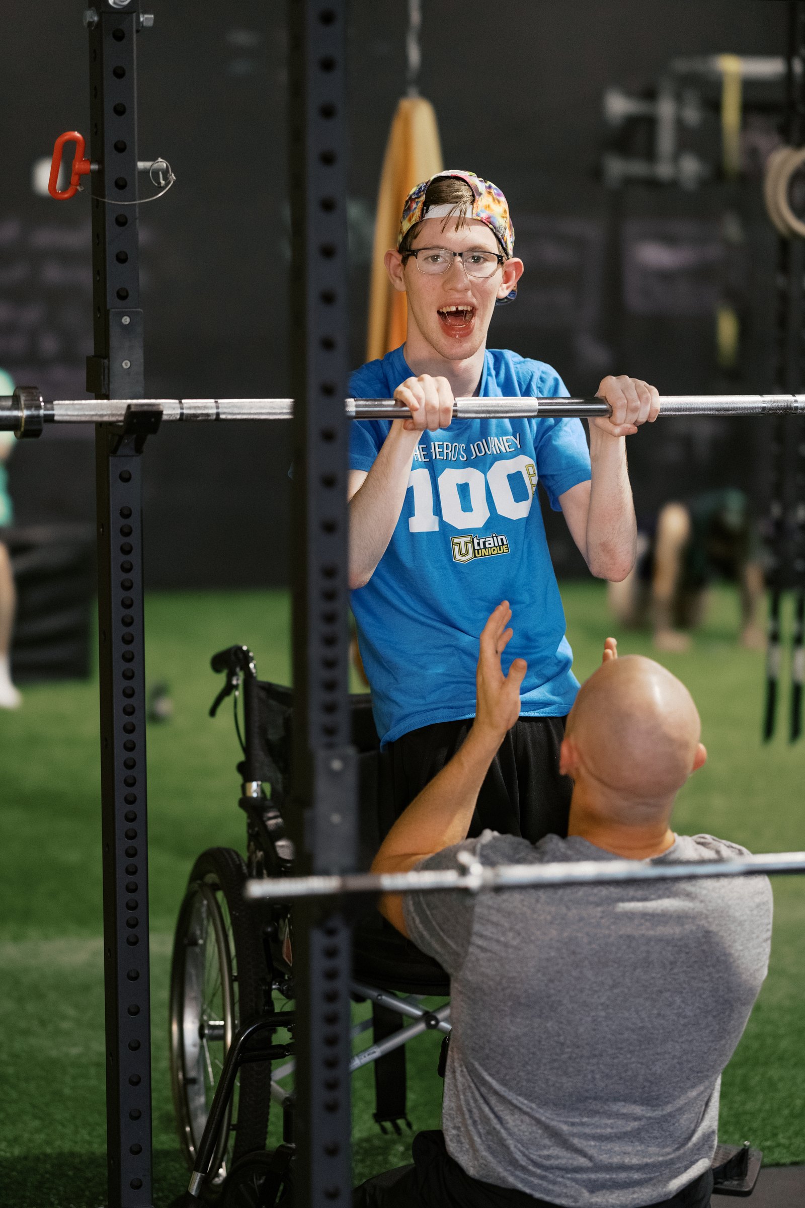 An athlete under the bar with a coach
